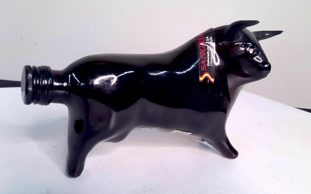 "Toro Sangría" Black Ceramic Bull-Form Bottle: "Toro Sangría" Black Ceramic Bull-Form Bottle Glossy black ceramic bottle molded as a standing bull with horns, screw cap at the muzzle. Label reads "SANGR?A, Elaborado por: T.S.A. (Tarra