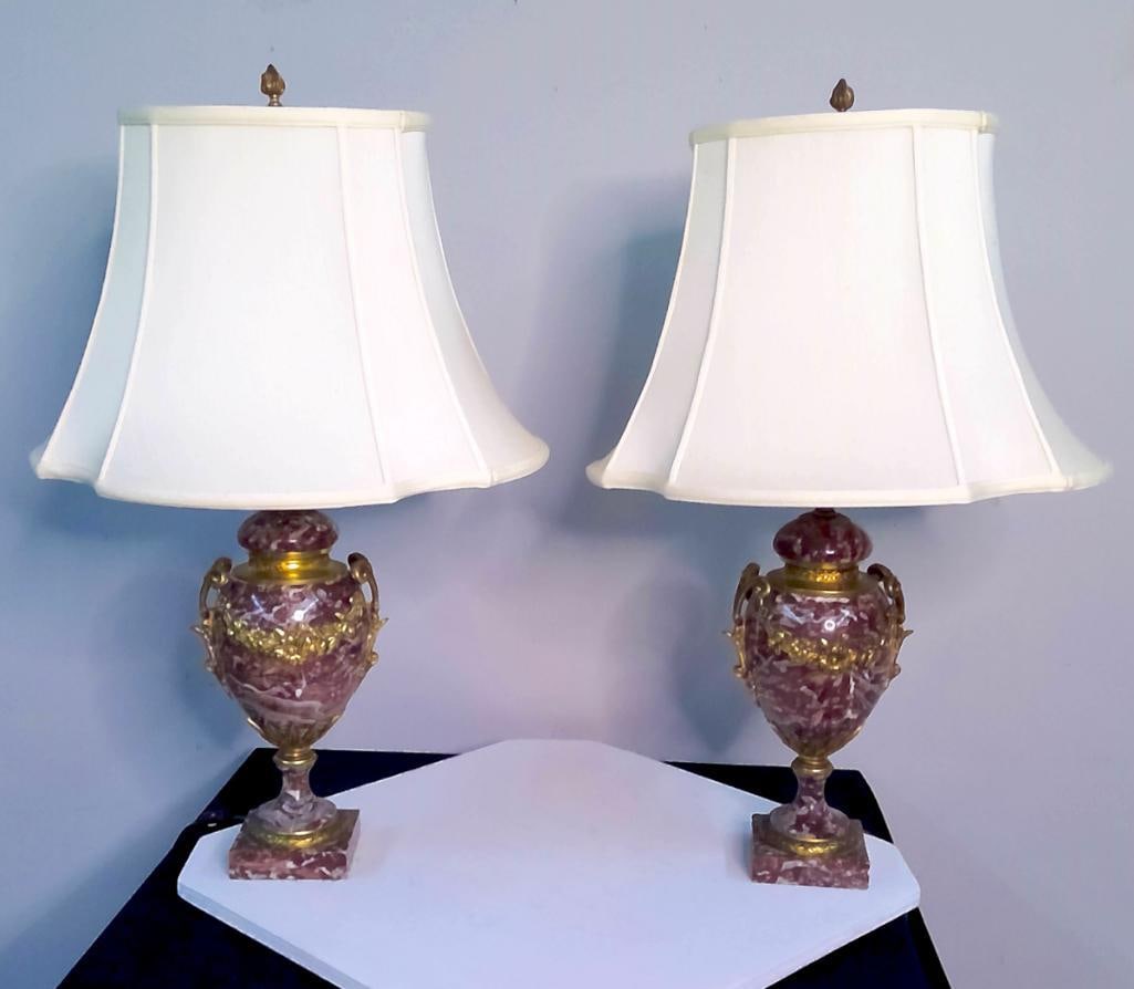 Pair of Louis XVI-Style Marble and Brass Table Lamps: A matched pair of neoclassical urn-form table lamps, each fashioned from richly veined burgundy and white marble and mounted with gilt-brass floral garlands, scrolling handles, foliate supports, and d