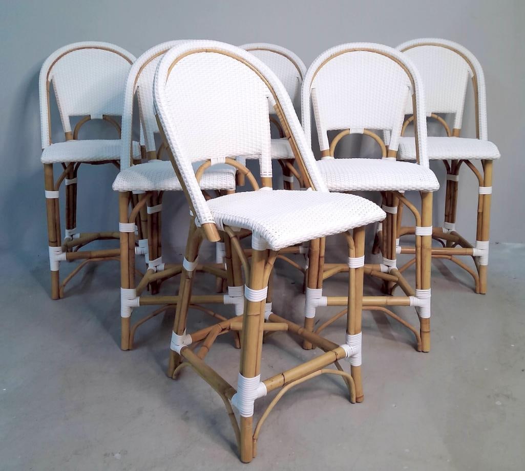 Serena and Lily Riviera Rattan Counter Stools, Set of Six: Six matching backless, armless, V-strap woven rattan bar stools, by Serena and Lily (brass nameplate and QR tag photographed with this lot). Dimensions: H 42 x W 19 x D 23 inches NOTE: Very Good, Like