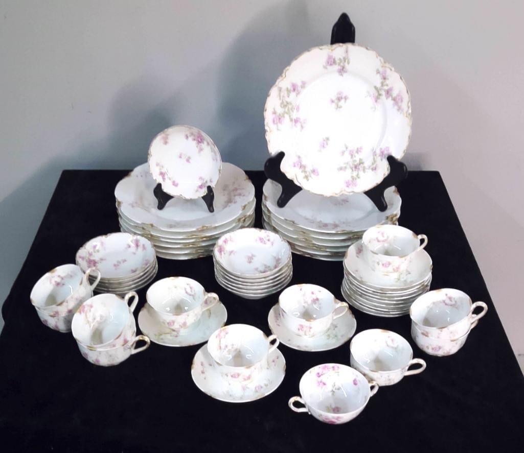 Haviland Limoges Floral Sprig Pattern Partial Service: 48 pieces. Haviland Limoges porcelain service decorated with a sprig pattern of small pink/lavender blossoms and green foliage within a gilt scalloped rim, marked to the reverse "Haviland France&#