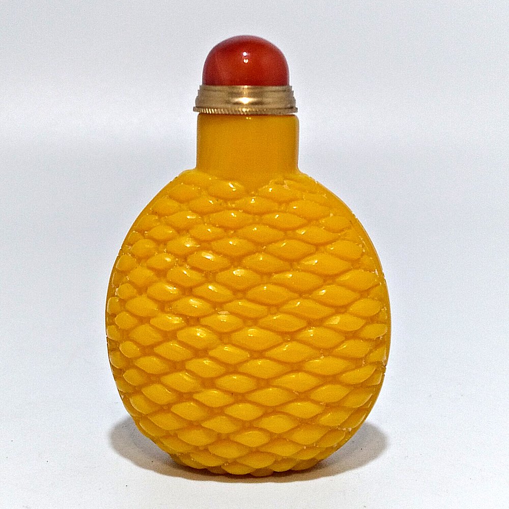 CHINESE IMPERIAL YELLOW PEKING GLASS BOTTLE: THE EXCELLENT BOTTLE CARVED IN BASKETWEAVE FORM AND TOPPED WITH A CARNELIAN AGATE STOPPER.THE BOTTLE IS 2.5 INCHES TALL. PROVENANCE: PRIVATE FLORIDA COLLECTION.