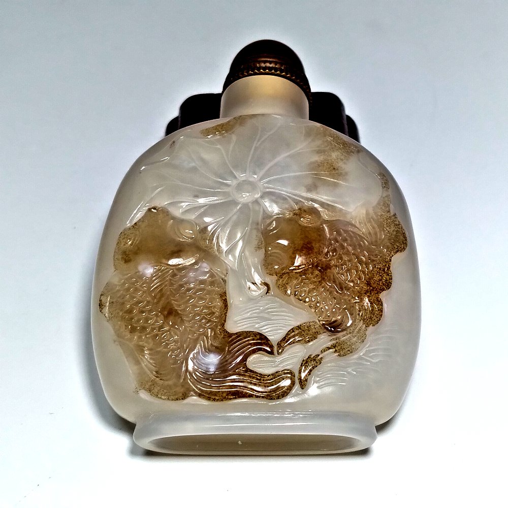RARE VERY FINE CHINESE CARVED AGATE SNUFF BOTTLE: THE RARE BOTTLE SO FINELY CARVED WITH MINUTE DETAIL . THE NATURAL COLORS OF THE AGATE ARE USED TO DEPICT TO LOVELY CARP AND A LARGE LOTUS LEAF. THE BOTTLE OF FLATTENED FLASK FORM HAS A WELL CARVED FOO