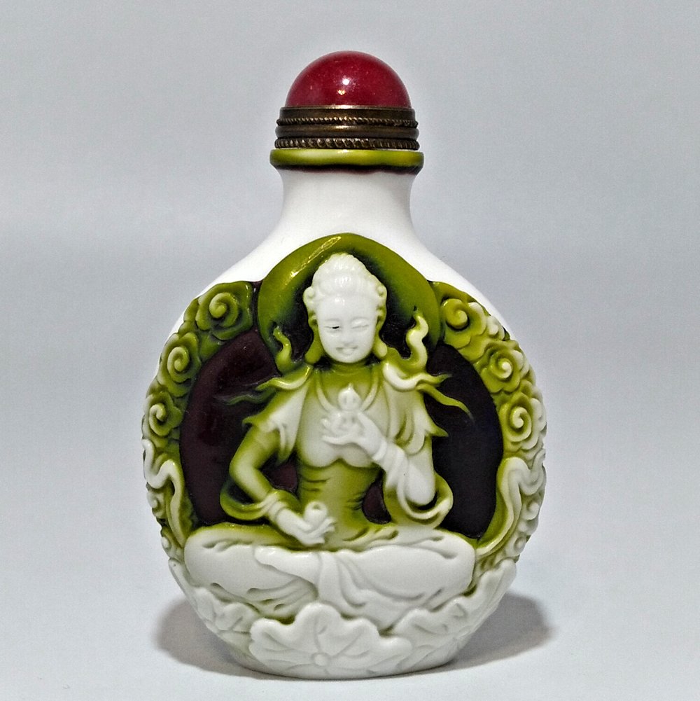 MAGNIFICENT PEKING GLASS SNUFF BOTTLE GUANYIN QIANLONG: THE MASTERFULLY CARVED BOTTLE WITH THE SMOOOTH LINES AND MUCH DETAIL, FEATURING GUANYIN SEATED ON BOTH SIDES. THE BOTTLE IS CARVED IN 4 LAYERS. IT BEARS THE QIANLONG DATE SEAL. PROVENANCE: PRIVATE COL