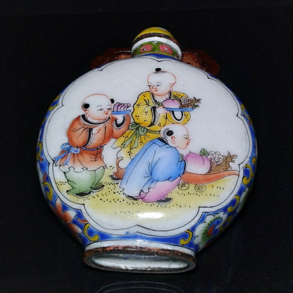 VERY FINE ENAMEL ON COPPER SNUFF BOTTLE CHILDREN: THE EXQUISITE BOTTLE IS SO FINELY ENAMELED WITH SCENE OF CHILDREN AT PLAY. THE BORDERS ARE DECORATED IN FAMILLE ROSE STYLE. THE ENAMEL IS IN FINE CONDITION AND THE BOTTLE BEARS A QIANLONG MARK. IT IS 