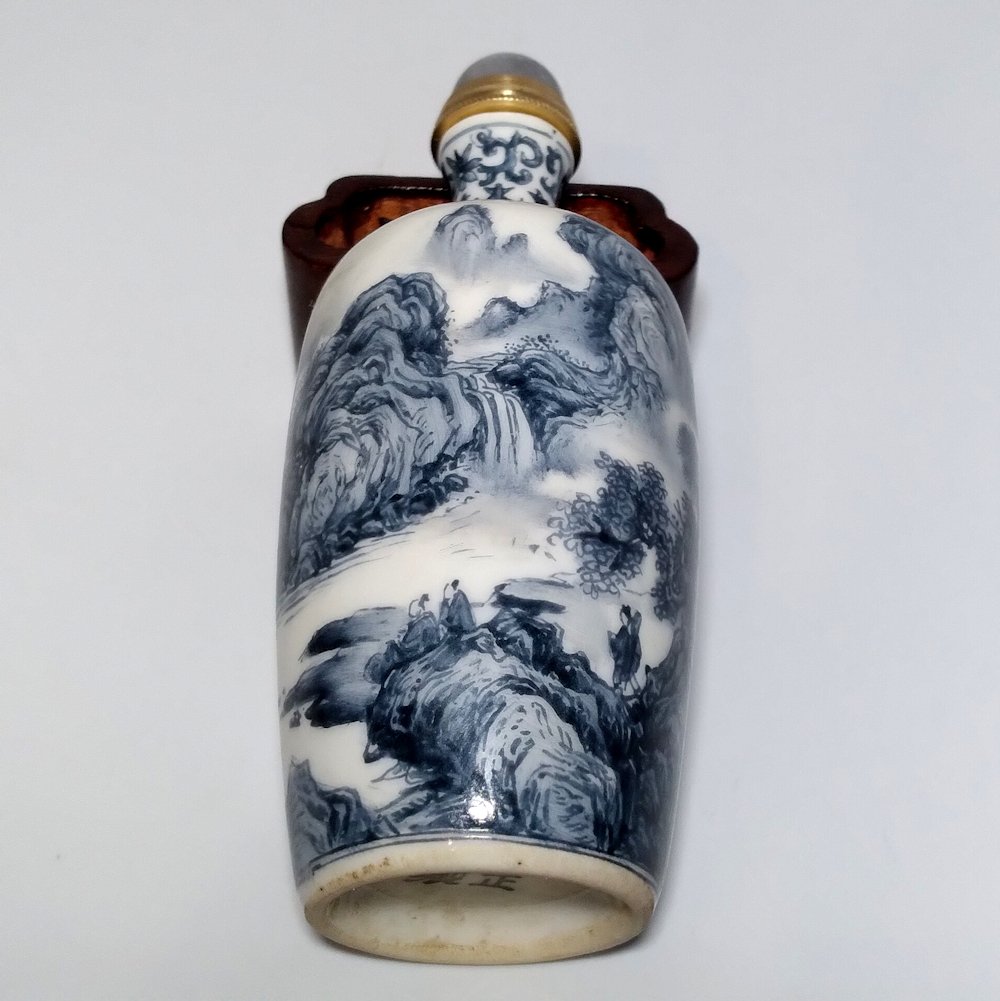 FINE CHINESE SNUFF BOTTLE ENAMEL PORCELAIN LANDSCAPE: THE FINE BOTTLE FEATURES EXQUISITE LANDSCAPES PAINTED ALL AROUND WITH A POEM INSCRIPTION AND THE ARTIST SIGNATURES. THE BOTTLE IS ALSO DECORATED IN BLUE AND WHITE UNDER GLAZE AROUND THE NECK. ITBEARS 