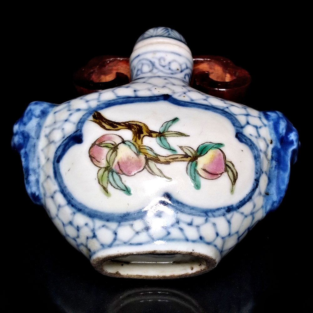 RARE CHINESE WUCAI PORCELAIN SNUFF BOTTLE KANGXI: THE BOTTLE IS DECORATED IN BLUE UNDER GLAZE AND TWO FRAMED IMAGES OF PEACHES ON A TREE BRANCH. THE BOTTLE IS 2.25 INCHES TALL AND 2.25 INCHES WIDE. PERIOD: 18TH CENTURY, KANGXI. PROVENANCE: MAJOR PRIV