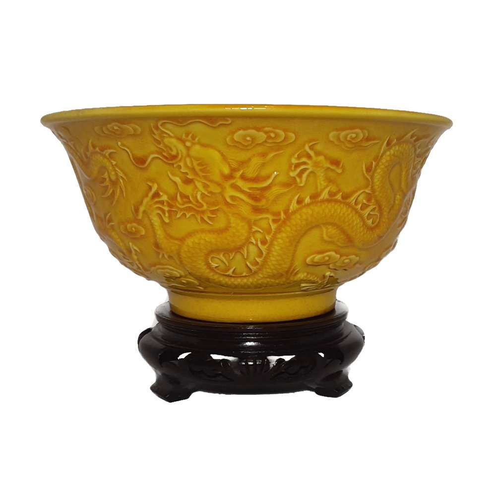 CHINESE PORCELAIN DRAGON BOWL IMPERIAL YELLOW QIANLONG MARK: the exquisite bowl with yellow glaze over carved relief imperial dragons and clouds. It has the incised 4 letter Qianlong period mark. 6 inches, 15 cm wide and 2.75 inches tall.