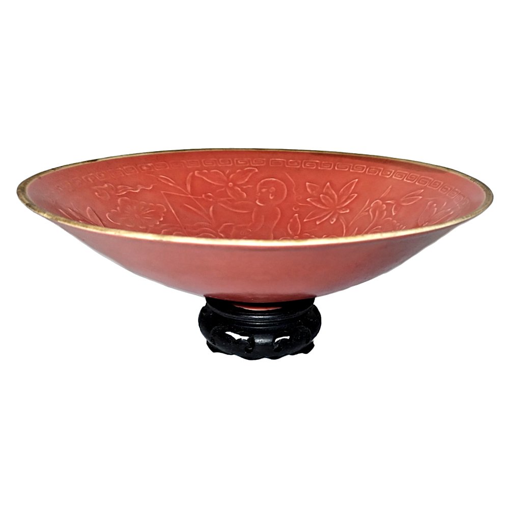 CHINESE PORCELAIN INCISED BOWL CORAL GLAZE CHILDREN: THE REFINED CHINESE BOWL WITH AN INCISED CHILDREN AND FLORAL PATTERN, LOTUS AND A STYLIZED CLOUD BORDER. IT IS 8 INCHES WIDE.THE GLAZE IS OF PEACH COLOR.