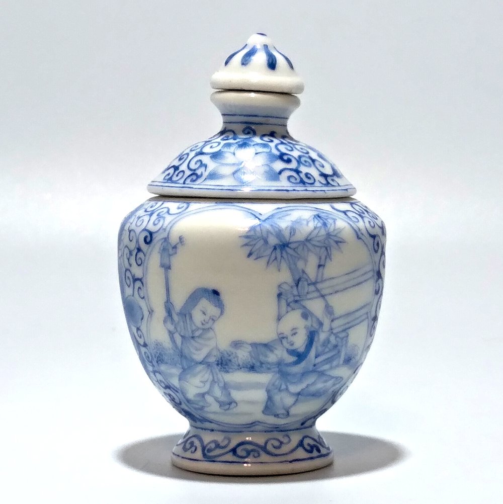 A FINE BLUE WHITE PORCELAIN ROTATING SNUFF BOTTLE: THE FINE, ROTATING, DOUBLE WALLED BOTTLE FEATURES CHILDREN AT PLAY. THE WORKMANSHIP IS BEAUTIFUL. THE BOTTLE IS IN VERY GOOD CONDITION AND IT BEARS A QIANLONG MARK.IT IS 2.8 INCHES TALL .PROVENANCE: M