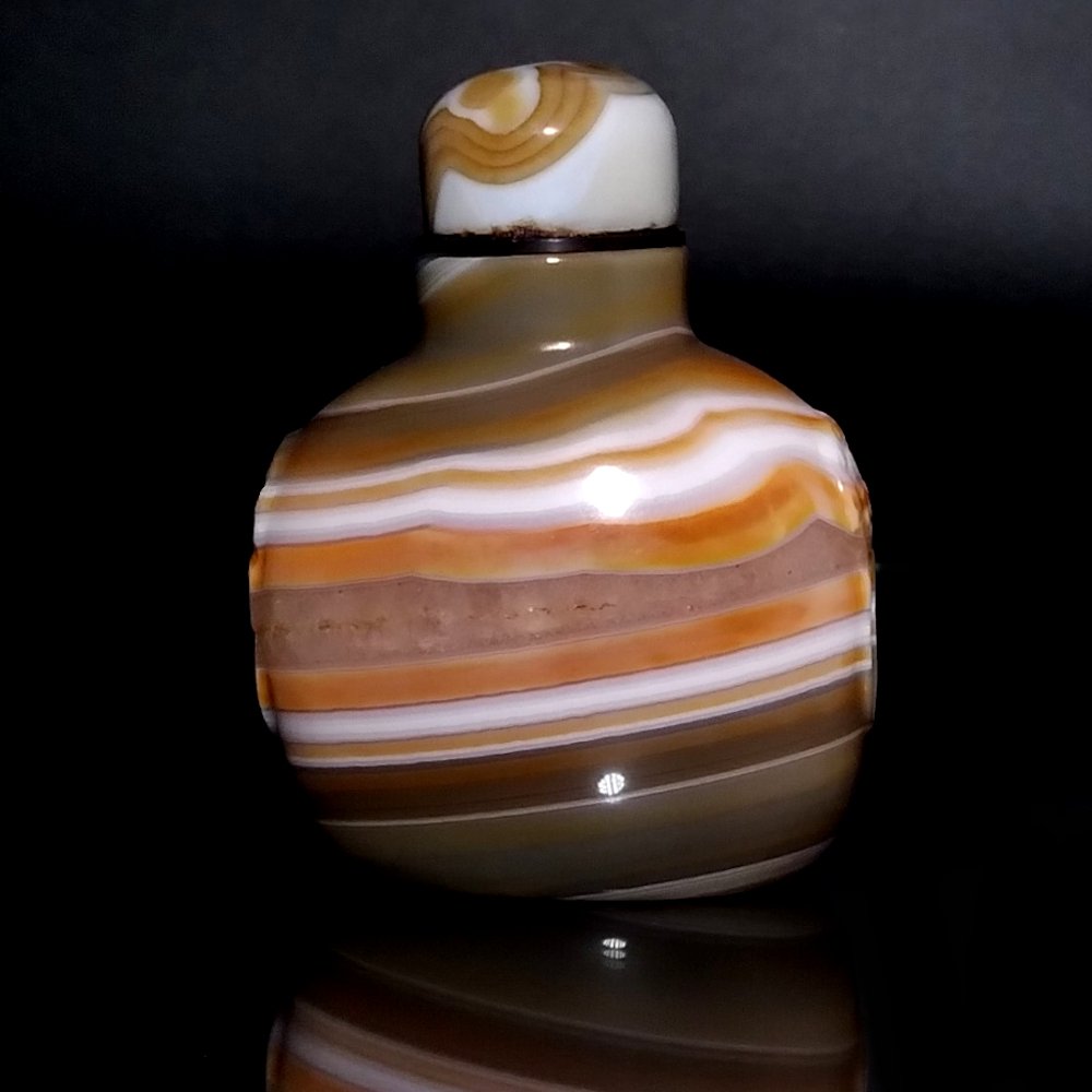 OUTSTANDING CHINESE CARVED BANDED AGATE SNUFF BOTTLE: THE CARVED AGATE BOTTLE OF BREATHTAKING BEAUTY. IT HAS WELL CARVED MASK SHOULDERS, FOOT AND MOUTH. THE BOTTLE IS 3 INCHES TALL AND 2.25 INCHES WIDE. PROVENANCE: MAJOR PRIVATE COLLECTION.