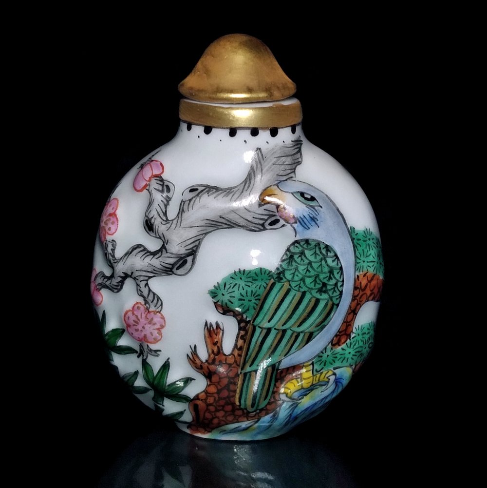 A FINELY ENAMELED AND MOLDED CHINESE PORCELAIN SNUFF BOTTLE: THE FINELY ENAMELED AND MOLDED BOTTLE FEATURES A BIRD ON A BRANCH AND FLOWERS. IT CARRIES A QIANLONG MARK. THE BOTTLE IS INSCRIBED WITH A POEM AND SIGNED. IS 2.4 INCHES TALL. PROVENANCE: PRIVATEFLORID