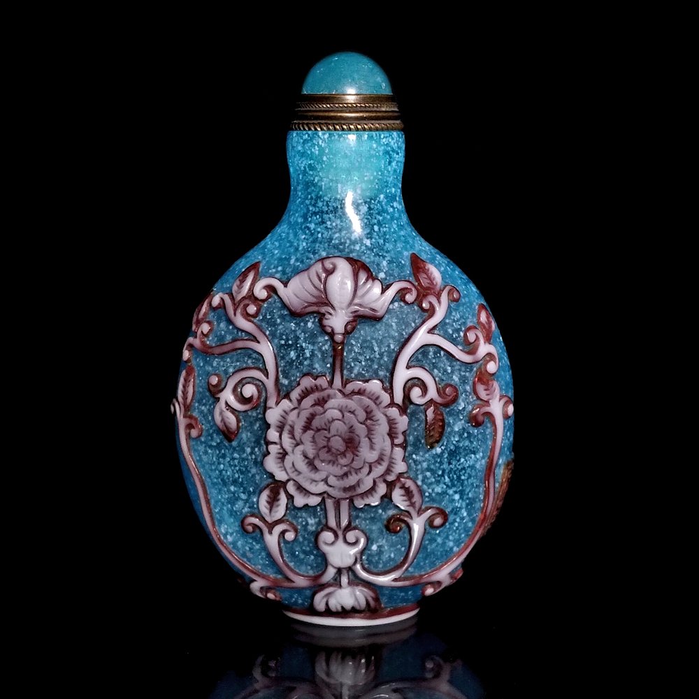 FINE CHINESE PEKING GLASS SNUFF BOTTLE BLUE WHITE: THE DELICATE BOTTLE IS FINELY CARVED IN THREE LAYERS OF GLASS. IT FEATURES BATS, LOTUS AND VINES. IT BEARS A QIANLONG CARVED MARK. THE BACKGROUND IS BUBBLE INFUSED LIGHT BLUE. THE BOTTLE IS 2.9 INCHES