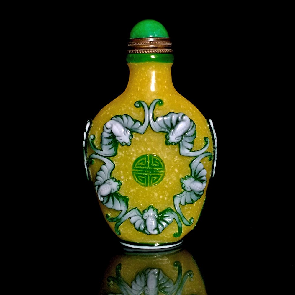 FINE CHINESE YELLOW PEKING GLASS SNUFF BOTTLE SHOU, BATS: THE FINE BOTTLE IS CARVED IN THREE LAYERS OF GLASS WITH A YELLOW BACKGROUND. IT FEATURES BATS AND A SHOU SYMBOL. IT BEARS A CARVED QIANLONG MARK. THE BOTTLE IS 3 INCHES TALL.