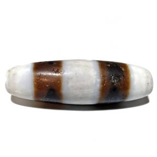 A RARE EXCELLENT DZI AGATE BEAD SINO-TIBETAN: THE OUTSTANDING AND RARE BEAD MEASURES 46MM. IT BEARS A FINE PATINA. PROPERTY OF A FLORIDA COLLECTOR. WE PROVIDE IN-HOUSE SHIPPING