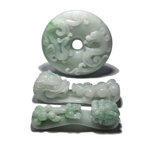 A FABULOUS CARVED JADEITE LOT, BUCKLES, BI: THIS IS AN EXQUISITE JADEITE LOT. ALL THREE ITEMS ARE BEAUTIFULLY CARVED IN NATURAL, UNDYED JADEITE. ALL CARRY A DRAGON MOTIF. THE BI IS 2.15 INCHES IN DIAMETER. THE BELT BUCKLES ARE 2.2 AND 2.25 INCH