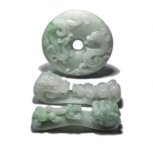 A FABULOUS CARVED JADEITE LOT, BUCKLES, BI: THIS IS AN EXQUISITE JADEITE LOT. ALL THREE ITEMS ARE BEAUTIFULLY CARVED IN NATURAL, UNDYED JADEITE. ALL CARRY A DRAGON MOTIF. THE BI IS 2.15 INCHES IN DIAMETER. THE BELT BUCKLES ARE 2.2 AND 2.25