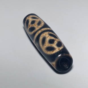 FINE SINO TIBETAN BUDDHIST AGATE DZI BEAD 56MM: THE BEAUTIFUL BEAD SHOWING FINE PATINA. IT IS 56MM LONG AND FEATURES BUDDHIST SYMBOLS. PROVENANCE: PRIVATE FLORIDA COLLECTION. WE PROVIDE IN-HOUSE SHIPPING.