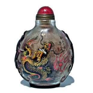 STUNNING CHINESE SIGNED PEKING GLASS SNUFF BOTTLE INSIDE PAINTED DRAGON: THE CHINESE PEKING GLASS SNUFF BOTTLE IS CARVED IN PURPLE OVER CLEAR GLASS WITH KYLINS ON BOTH SHOULDERS AND PAINTED INSIDE WITH FIERCE DRAGONS. THE BOTTLE IS INSCRIBED AND SIGNED. IT IS 3 INCHES TALL