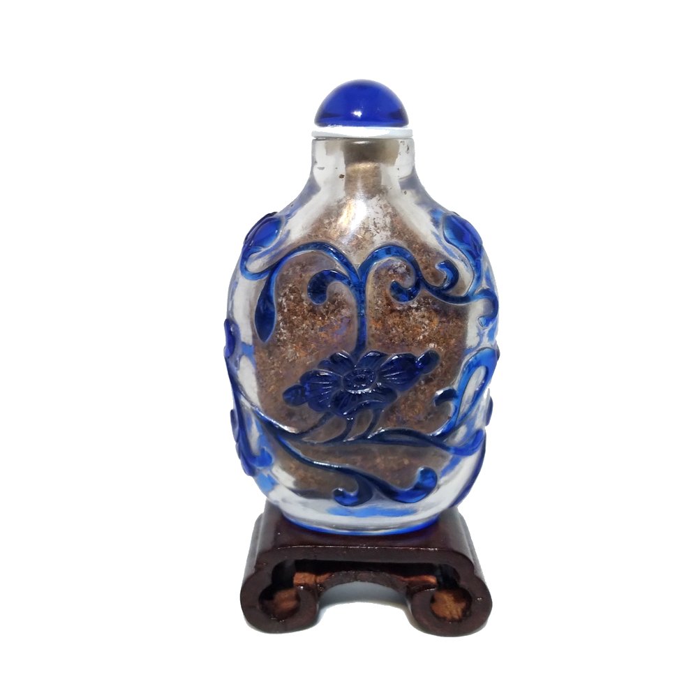 ANTIQUE CHINESE PEKING GLASS SNUFF BOTTLE FLORA QING 18-19C: THE ANTIQUE CHINESE SNUFF BOTTLE IS SO WELL CARVED FLORA AND SCROLLING VINES, IN BLUE OVER CLEAR GLASS. THE BOTTLE IS 2.75 INCHES TALL. ESTIMATED AGE CIRCA 18-19C, QING DYNASTY. STANDS ARE FOR DISPLAY