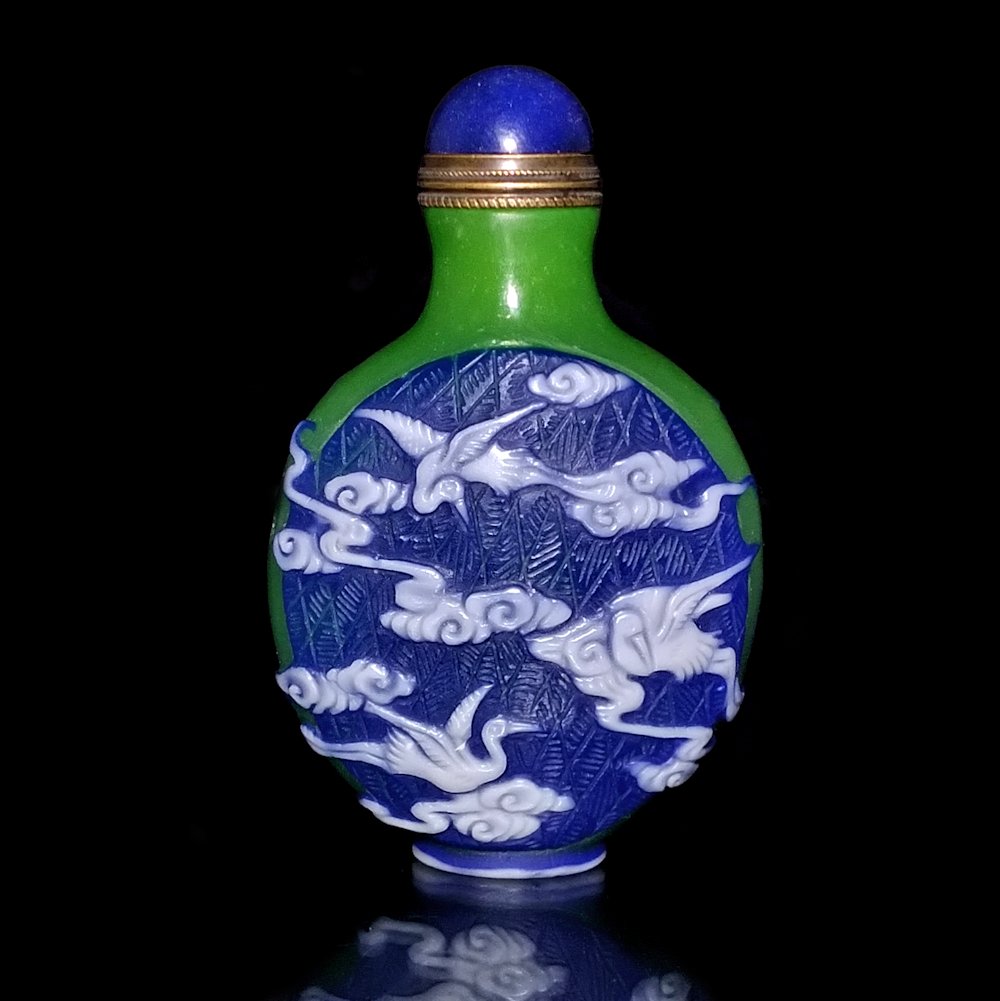 FINE CHINESE PEKING GLASS SNUFF BOTTLE STORKS CLOUDS: THE BEAUTIFULLY CHINESE CARVED SNUFF BOTTLE IS OF AN UNUSUAL DESIGN. IT IS CARVED WITH A STORK AND CLOUD MOTIF, IN THREE LAYERS OF COLOR. THE BOTTLE IS 3.15 INCHES TALL. STANDS ARE FOR DISPLAY ONLY, N
