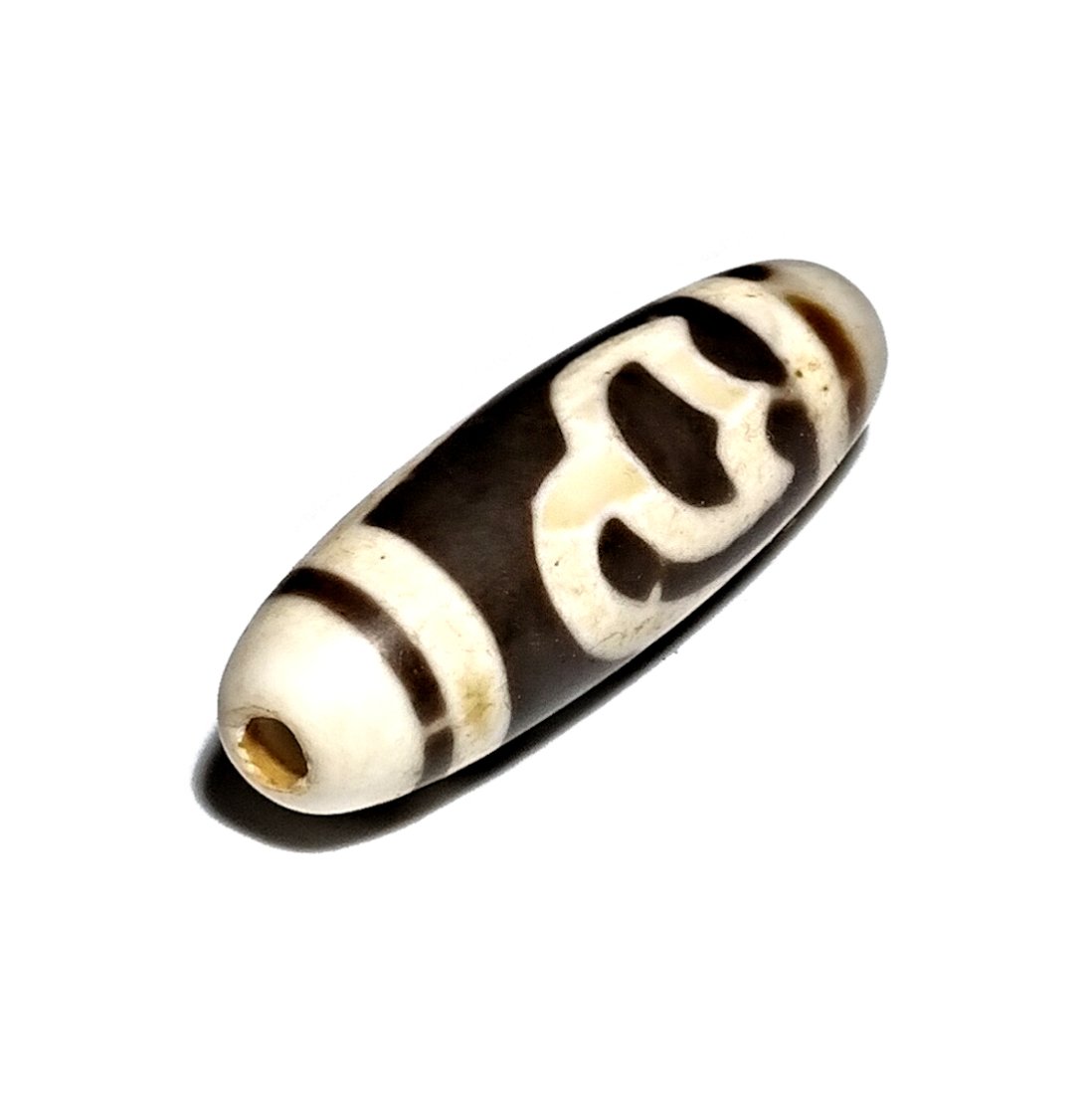 SINO TIBETAN AGATE DZI BEAD DOUBLE LOTUS: THE BEAUTIFUL AGATE DZI BEAD FEATURING A DOUBLE LOTUS AND TWO STRIPES. THE BEAD HAS WEAR FROM AGE. IT IS 33 MM LONG. PROVENANCE: PRIVATE FLORIDA COLLECTION.