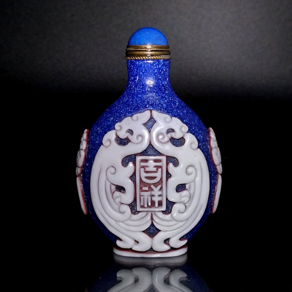 CHINESE PEKING GLASS SNUFF BOTTLE ARCHAISTIC DRAGONS: THE BEAUTIFUL CARVED CHINESE PEKING GLASS SNUFF BOTTLE FEATURES ARCHAISTIC DRAGONS AND INSCRIPTIONS, AS WELL AS MASK AND RING SHOULDERS. IT IS CARVED WITH 3 BEAUTIFULLY CONTRASTING LAYERSOF GLASS COLO