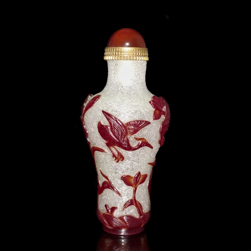 SUPERB CHINESE PEKING GLASS SNUFF BOTTLE 19TH C STORKS LOTUS: THE FINE CHINESE SNUFF BOTTLE FEATURES STORKS AND LOTUS IN A CONTINUOUS IMAGE. THE BUBBLE INFUSED BACKGROUND IS FINELY ETCHED. THE TRUE COLOR OF THE CARVING IS A DEEP REDDISH BROWN, QUITEDARKERTHAN PI
