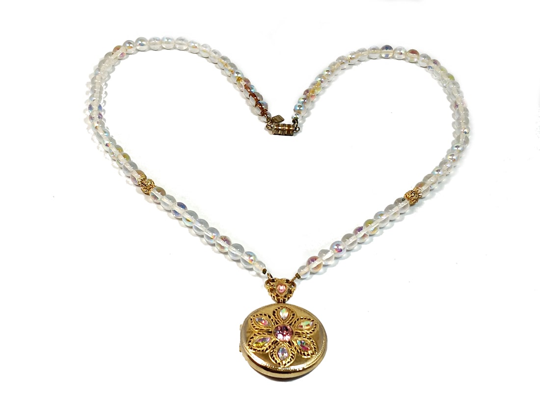 AN IRRIDESCENT GLASS NECKLACE WITH A LOCKET SIGNED 1928: THE NECLACE IS 28" LONG, SIGNED 1928. STANDS ARE FOR DISPLAY ONLY, NOT INCLUDED UNLESS OTHERWISE STATED. PROPERTY OF A FLORIDA COLLECTOR. WE COMBINE/PROVIDE IN-HOUSE SHIPPING.