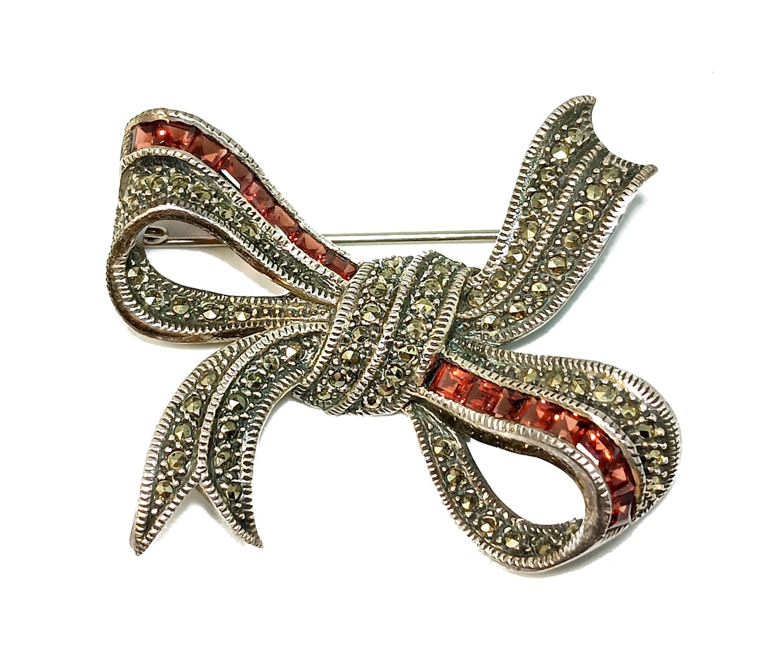 A BEAUTIFUL VINTAGE BROOCH GARNETS STERLING MARCASITES SIGNED JUDITH JACK: OFFERED HERE IS A BEAUTIFUL VINTAGE BROOCH GARNETS STERLING MARCASITES SIGNED JUDITH JACK. IT MEASURES 2" BY 1.5" AND IT WEIGHS 18 GRAMS. WE PROVIDE IN-HOUSE/COMBINED SHIPPING FOR YOURCONVENIENCE. HAV