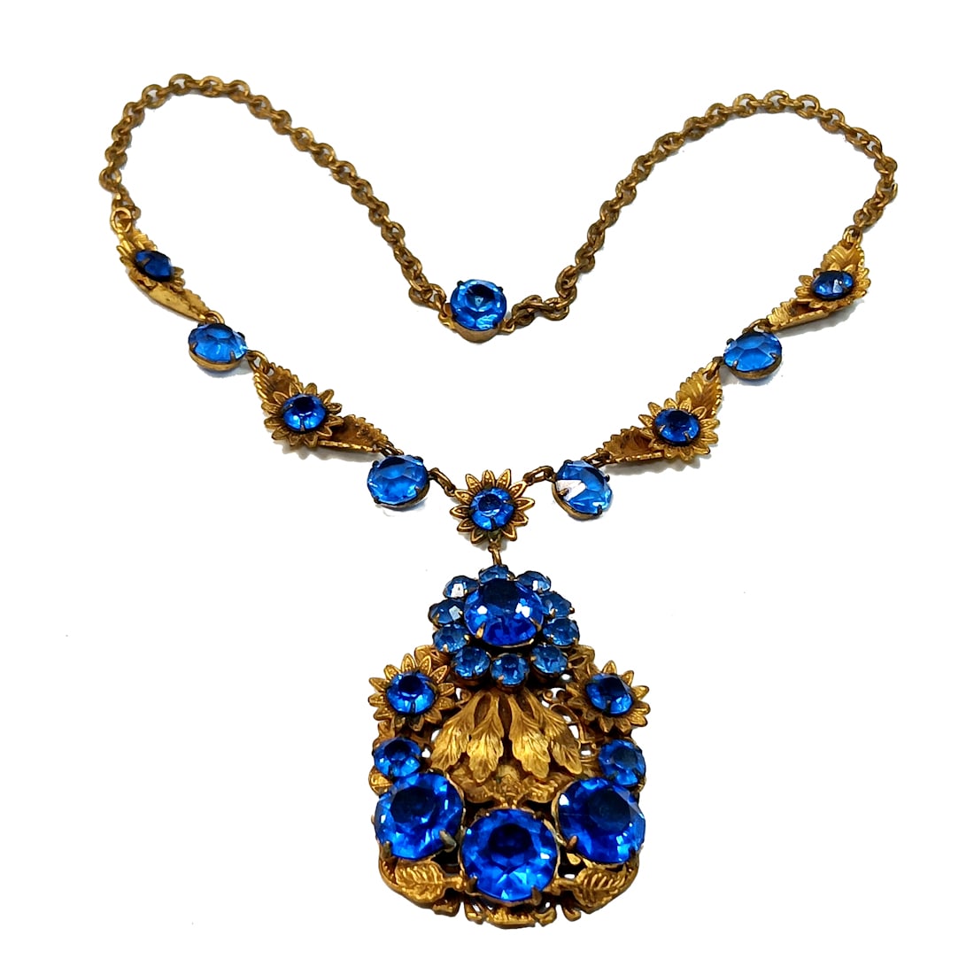 AN EXQUISITE ART DECO BLUE CZECH NECKLACE: OFFERED HERE IS AN EXQUISITE ART DECO BLUE CZECH NECKLACE. THE NECKLACE IS MADE OF GILDED BRASS AND FACETED GLASS IN A BLUE SAPPHIRE COLOR. IT IS 16" LONG. IT FEATURES A FLOWER AND LEAF PATTERN. NOT M