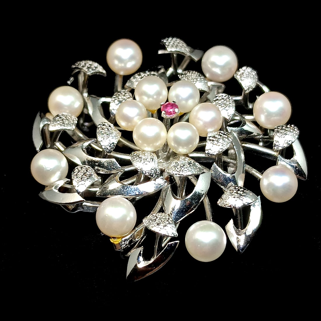 AN OUTSTANDING BROOCH OF JAPANESE AKOYA CULTURED PEARLS STERLING SILVER: THE HIGH QUALITY VINTAGE BROOCH MEASURES 1.75" IN DIAMETER. IT IS SET WITH AKOYA PEARLS OF AAA QUALITY WITH DEEP GLOWING NACRE. THERE IS A SMALL RUBY SET IN THE CENTER. THERE ARE 14 PEARLS MEASURING F