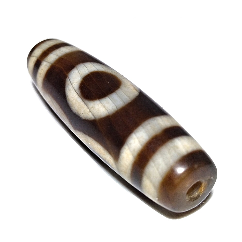 SINO-TIBETAN AGATE DZI BEAD 3 EYES 42MM: THE BEAUTIFUL SINO-TIBETAN AGATE DZI BEAD FEATURES 3 EYES. IT IS 42MM LONG AND FEATURES PATINA FROM AGE. WE COMBINE/PROVIDE IN-HOUSE SHIPPING.