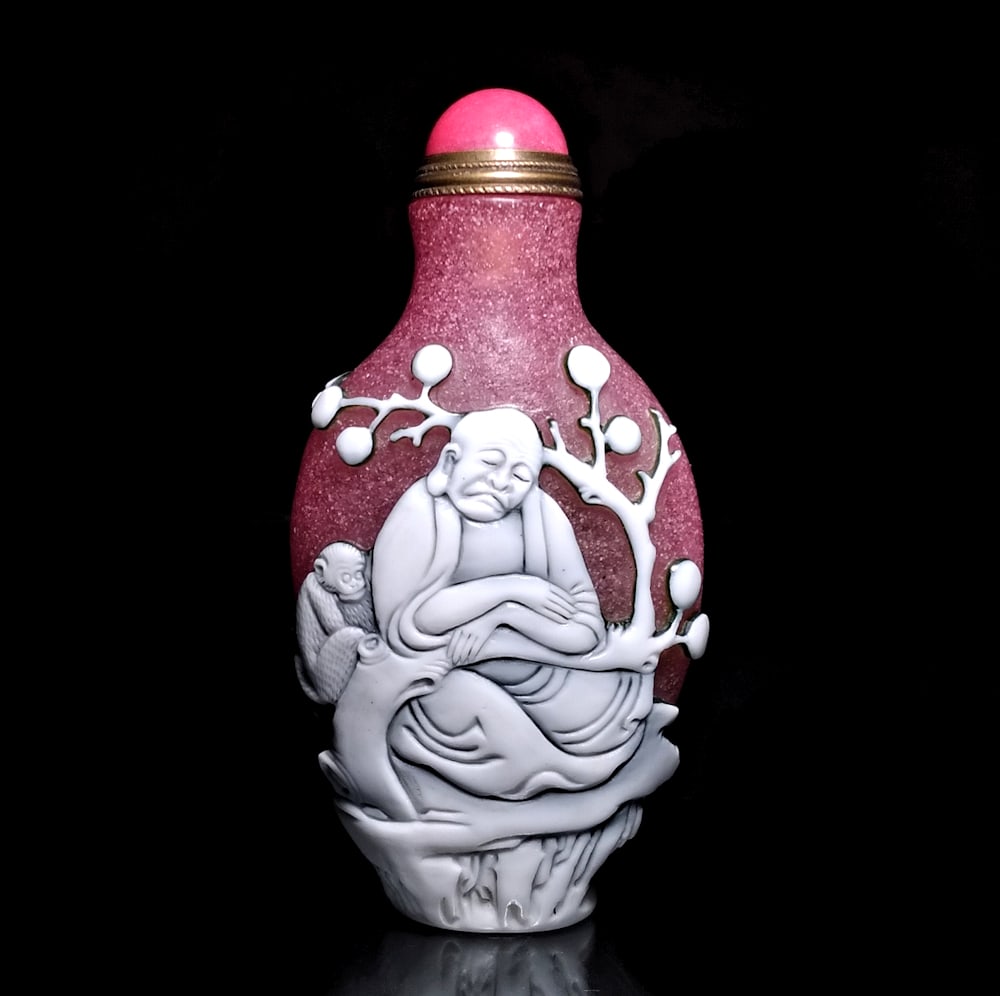 FINE CHINESE PEKING GLASS SNUFF BOTTLE FEATURING LOHANS: THE FINELY CARVED CHINESE PEKING GLASS SNUFF BOTTLE FEATURES THREE DIFFERENT LOHANS. ONE IS TELLING A FUNNY TALE TO HIS FRIEND, WHILE ANOTHER IS MEDITATING UNDER A TREE WITH A MONKEY WATCHING HIM. THE