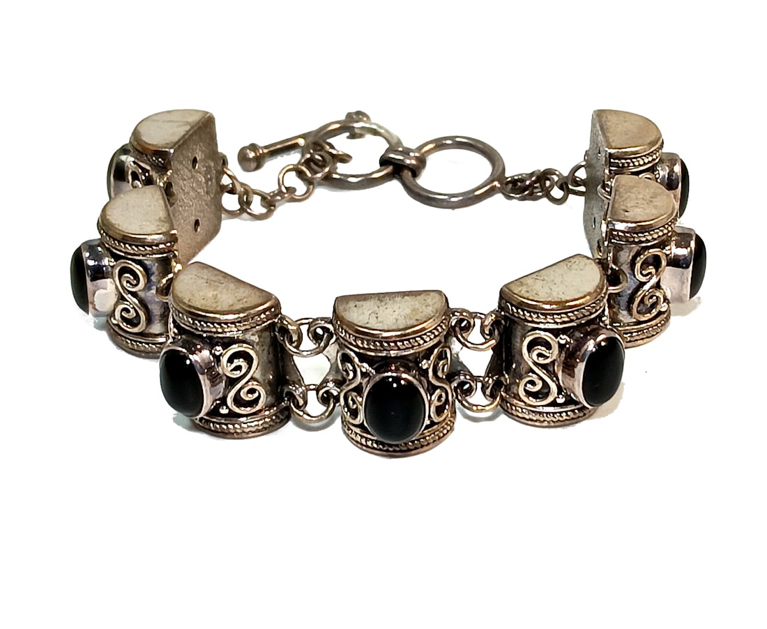 AN ESTATE BRACELET IN STERLING SILVER AND ONYX 7.5" LONG 29 GRAMS: OFFERED HERE IS AN ESTATE BRACELET IN STERLING SILVER AND ONYX. IT IS 7.5" LONG AND IT WEIGHS 29 GRAMS. IT IS MARKED 925 AND WE HAVE ALSO TESTED THE SILVER. WE PROVIDE IN-HOUSE SHIPPING FOR YOUR CONVE