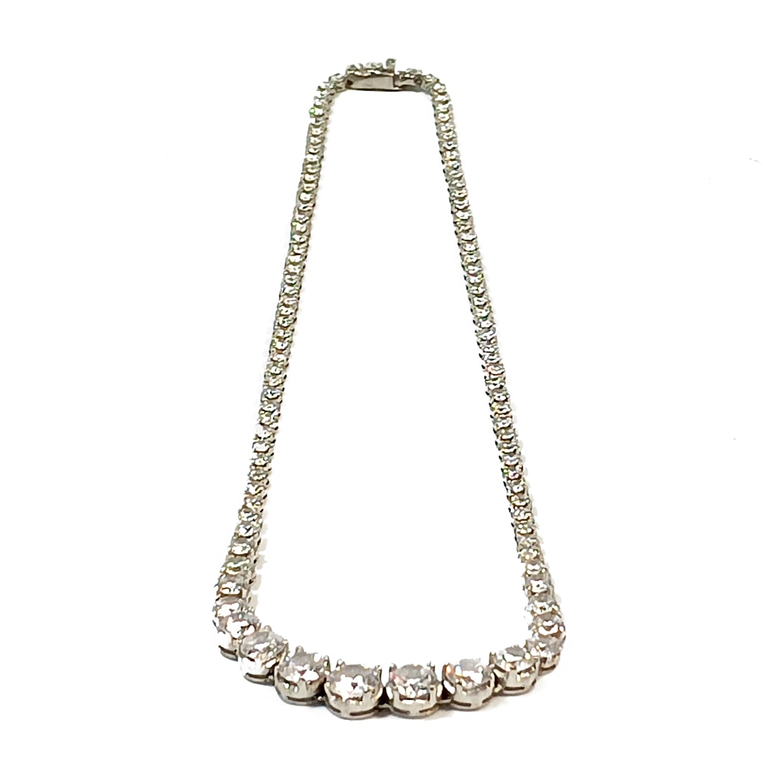 A GRADUATED CUBIC ZIRCONIA NECKLACE 17": OFFERED HERE IS A GRADUATED CUBIC ZIRCONIA NECKLACE. IT IS RHODIUM PLATED AND WELL MADE FOR A " REAL" LOOK. THE NECKLACE MEASURES 17" LONG. WE PROVIDE FREE IN-HOUSE SHIPPING WITHIN THE U.S.