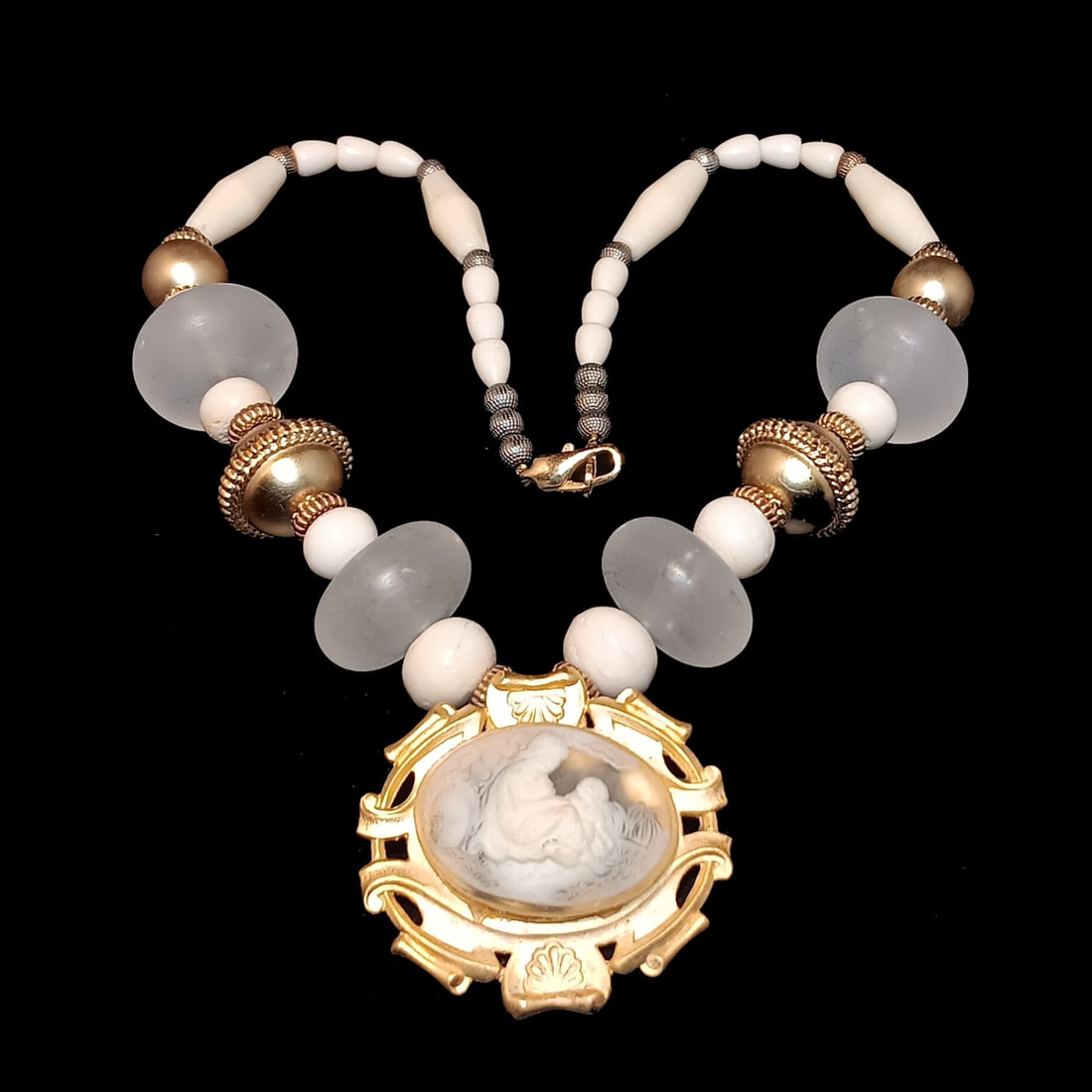 AN ELEGANT VINTAGE NECKLACE 21" CAMEO LUCITE PENDANT: THIS BEAUTIFUL VINTAGE NECKLACE IS 21" LONG. THE PENDANT IS 2" BY 2.25" AND FEATURES A LUCITE CARVED CAMEO MOTHER WITH CHILD. WE PROVIDE FREE IN-HOUSE SHIPPING WITHIN THE U.S.