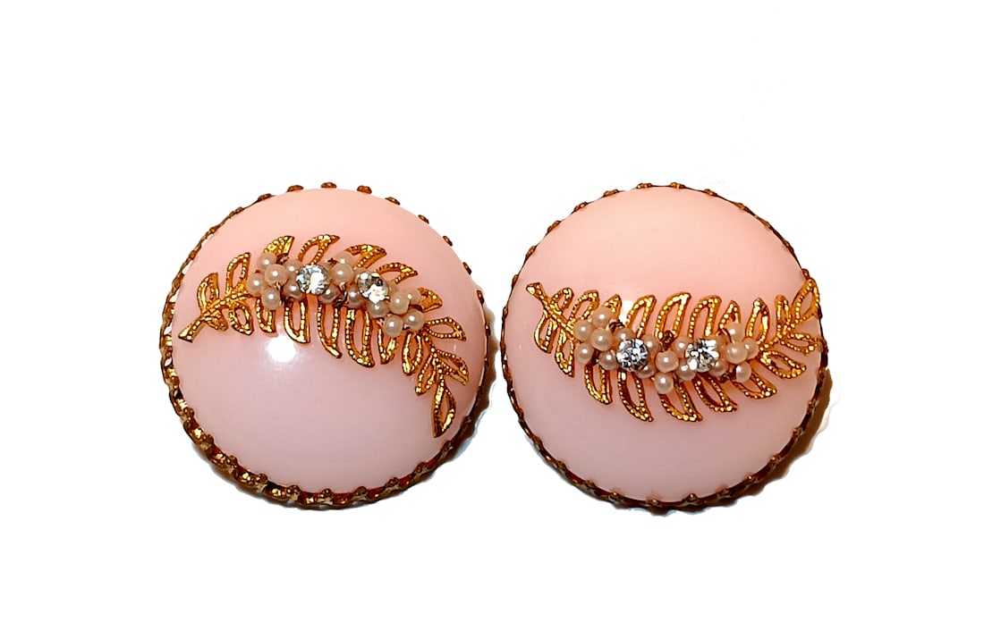 VINTAGE PINK LUCITE CLIP-ON EARRINGS WITH GOLD LEAF & FAUX PEARL ACCENTS 1950S STYLE: A BEAUTIFUL VINTAGE EARRINGS FEATURING DOMED PINK LUCITE CABOCHONS ADORNED WITH GOLD-TONE FILIGREE LEAVES, FAUX PEARLS, AND RHINESTONE ACCENTS. CLIP-ON BACKS. EACH EARRING MEASURES APPROX. 1.4" IN DIA