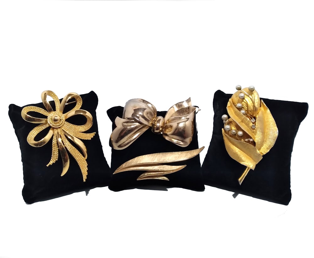 VINTAGE SIGNED COSTUME JEWELRY LOT 4 BROOCHES TRIFARI MONET: THIS LOT FEATURES 4 LARGE BROOCHES. A CROWN TRIFARI STYLIZED LEAF BROOCH, 2 MONET BOW BROOCHES AND A RICHELIEU LEAF AND PEARL BROOCH. ALL IN VERY GOOD CONDITION. ALL LARGE, 3" TO 3.25" IN LENGTH. WE P