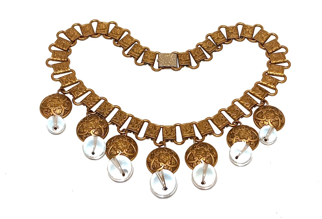 ANTIQUE "POOL OF LIGHT" ROCK CRYSTAL & BRASS BOOK CHAIN NECKLACE 15" C. 1900-1920: RARE ANTIQUE NECKLACE FEATURING ROCK CRYSTAL"POOLS OF LIGHT" BEADS (LARGEST 17MM) SUSPENDED FROM EMBOSSED REPOUSSE BRASS DISCS ON AN ORNATE BOOK CHAIN. MEASURES 15" LONG. A CAPTIVATING EXAMPLE OF EARL