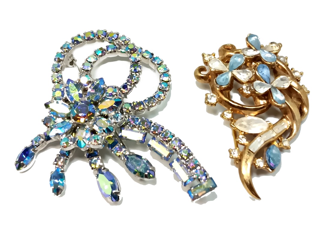 TWO BEAUTIFUL VINTAGE RHINESTONE BROOCHES INCLUDING TRIFARI: OFFERED HERE IS A LOT OF TWO VINTAGE RHINESTONE BROOCHES INCLUDING A CROWN TRIFARI BROOCH. THE AURORA BLUE BROOCH IS 2.5" LONG AND THE TRIFARI BROOCH 2" LONG. WE PROVIDE FREE IN-HOUSE SHIPPING WITHIN 