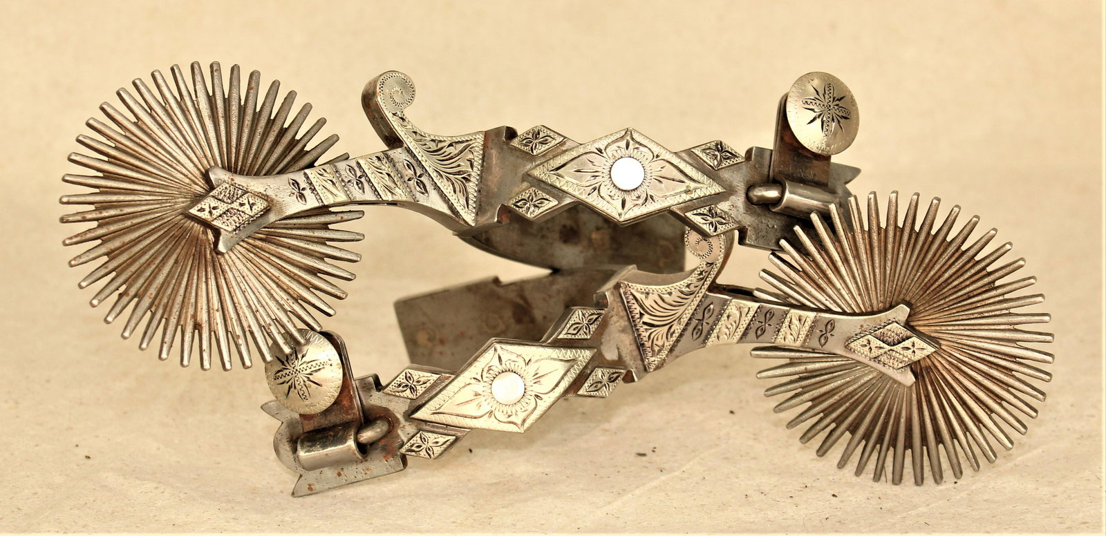 L&M Silver Spurs: Spectacular pair of oversized double mounted spurs with mother of pearl inlaid diamond and signature massive multi-point rowels.