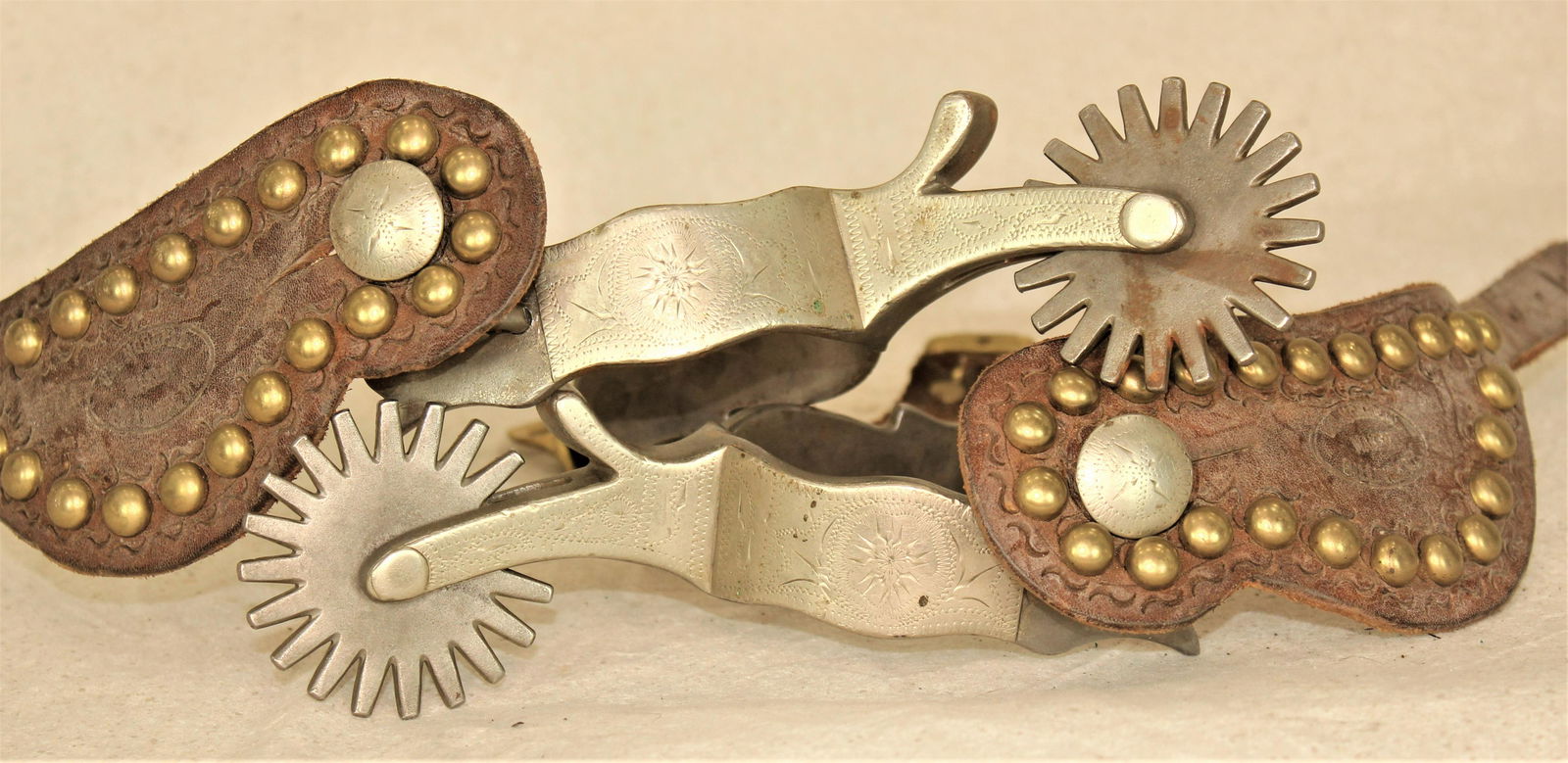 Crockett Spurs: Large pair of single mounted spurs with scalloped heelbands and large rowels.