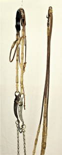 Rawhide & Leather Bridle: Appealing rawhide and leather braided bridle with highly detailed romel reins, cheekpieces, and finely engraved silver inlaid halfbreed banana shank bit. Category: Bridle