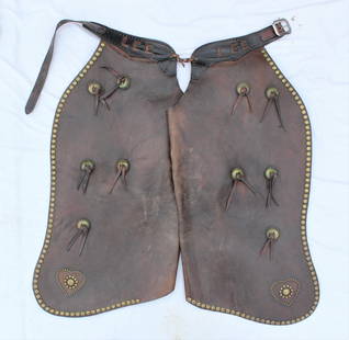 Studded Batwing Chaps: Large pair of russet colored batwing chaps, adorned with 10 brass saddlestring conchos and brass studded border and hearts. Category: Chaps