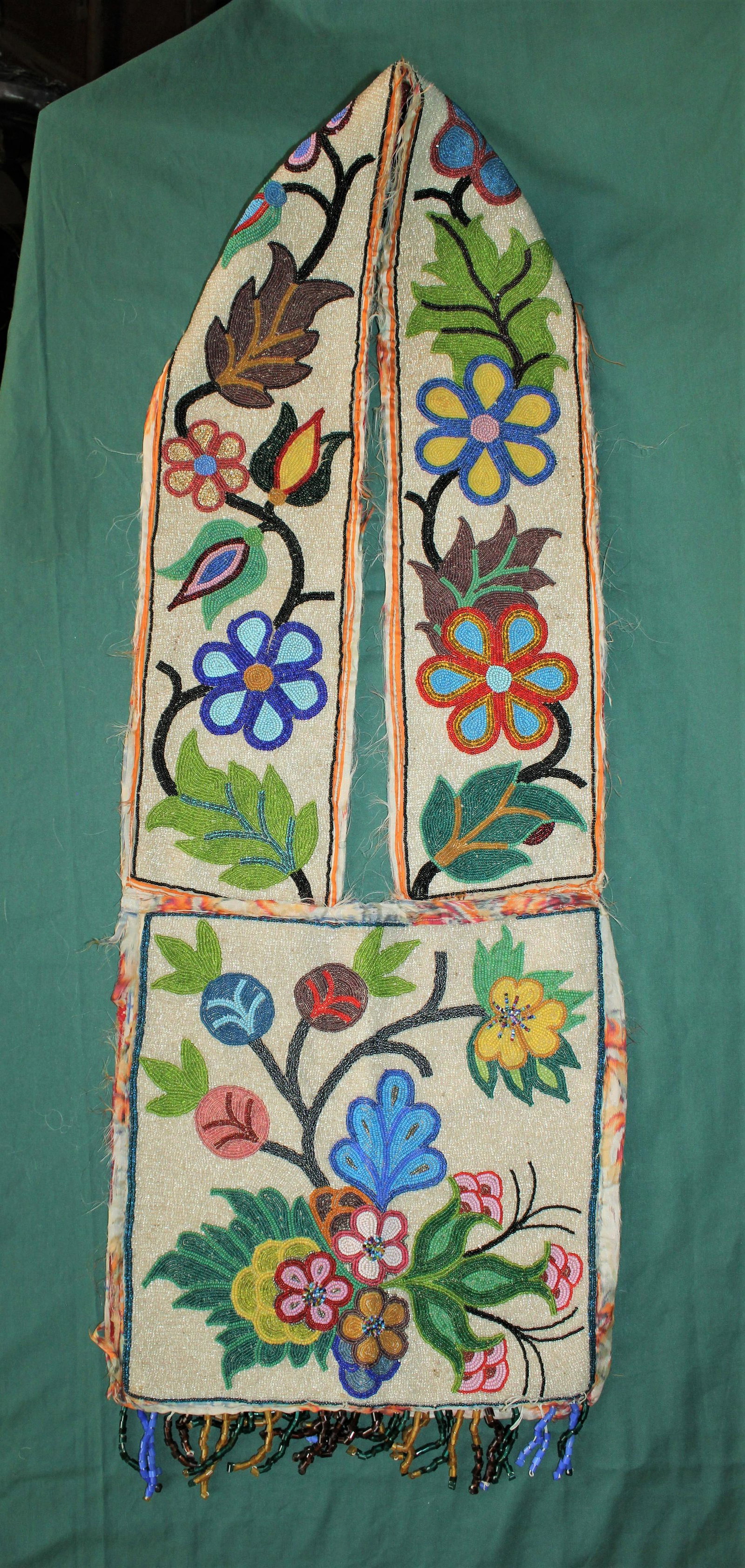 Beaded Bandelier Bag: Attractive Woodlands Indian beaded bandolier bag with brilliant colored floral pattern on full translucent background. Dimensions 12"x 34".