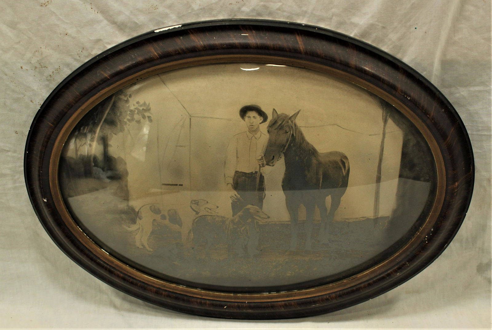 Western Photograph: Interesting early western photograph of a man, his horse and dogs. In original frame with bubble glass. Measurements 17"x 23".