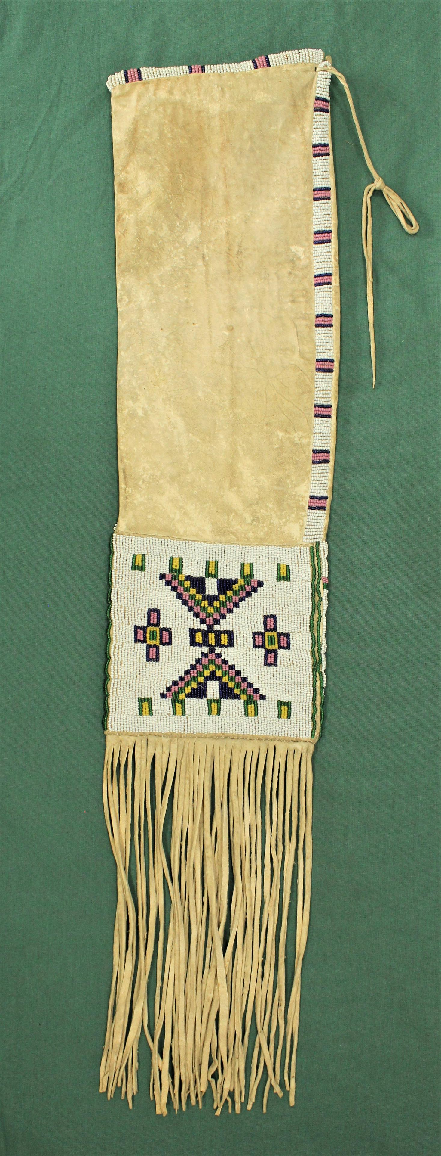 Beaded Pipe Bag: Nicely presenting hide bag with great patina, beaded with appealing geometric pattern and set of by fine fringe.