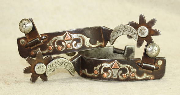 Texas Style Spurs: An intriguing pair of double mounted spurs with beautifully mounted two-tone heelbands, cresent moon shanks, and swinging buttons. Maker marked "PRC".