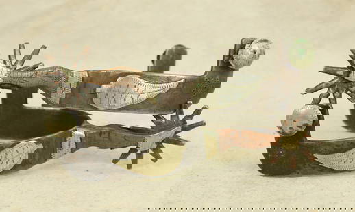 Gal Leg Spurs: A pair of interesting Texas style of double mounted spurs with lady leg shanks, wide heelbands, and intriguing dotted sunburst maker's mark. Showing nice patina and condition.