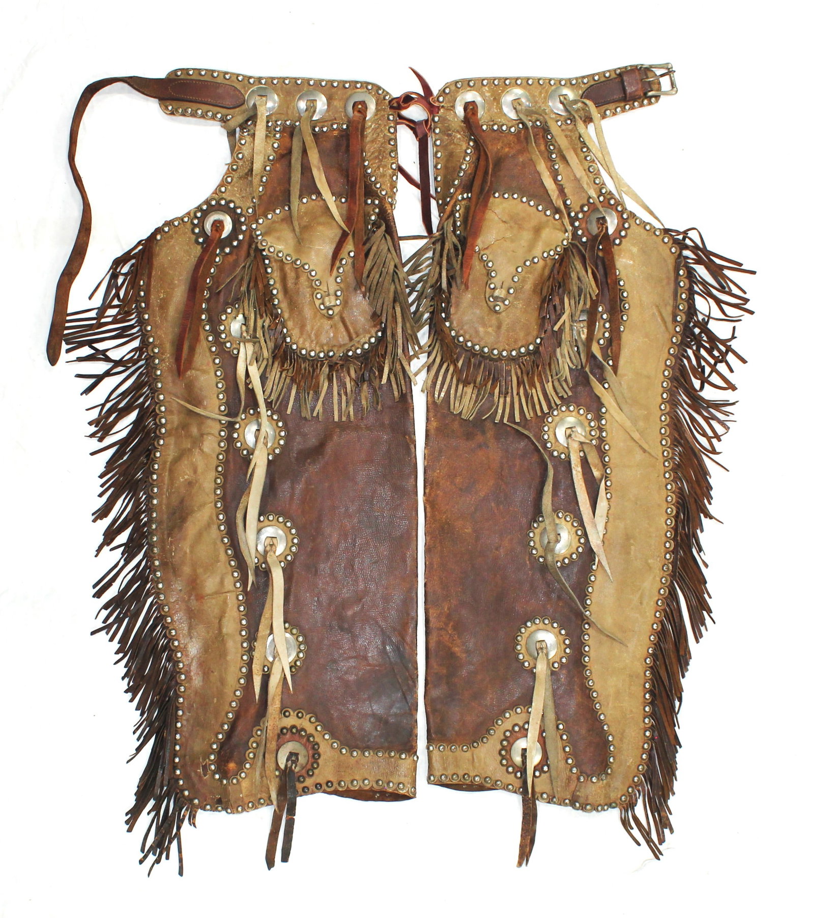Extra Fancy Batwing Chaps: A very large pair of eye-dazzling two tone batwing chaps, with incredible fringed pockets and wings, highlighted by saddlestring conchos and profuse stud pattern throughout. With tremendous eye appeal